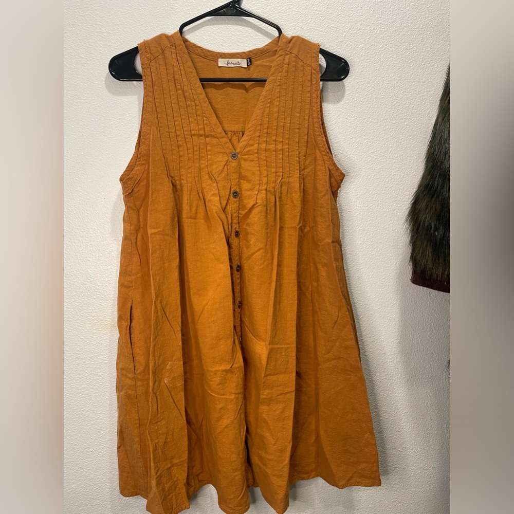 Beautiful mustard yellow sleeveless shirt with pleated details.